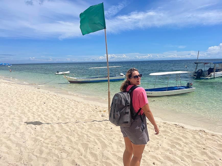 Solo traveler with backpack exploring Tubod Beach in Siquijor